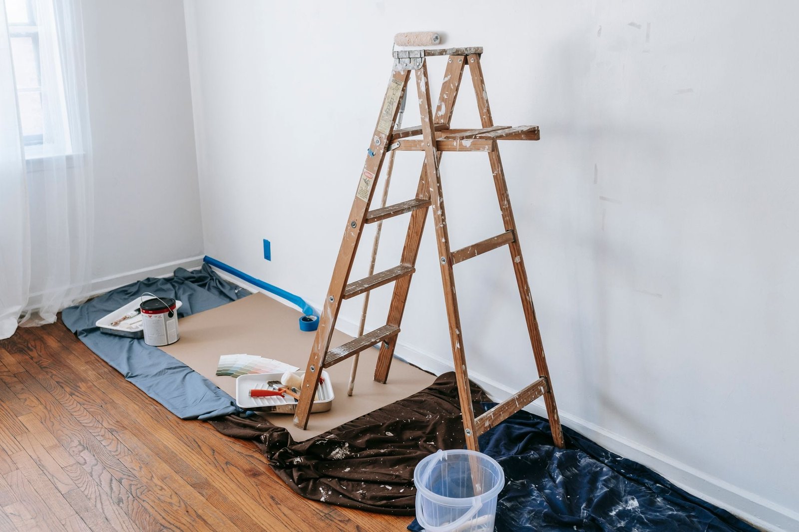 Houten trapladder in een kamer met afdekfolie op de vloer
